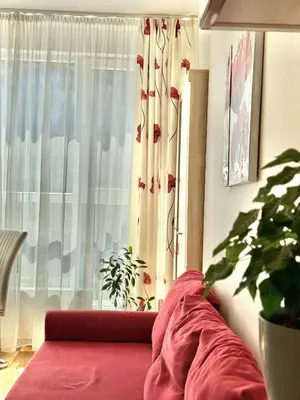 a living room with a red couch and a window at Sunny & Comfort Apartment next to Tech Park for 4 Guests in Sofia