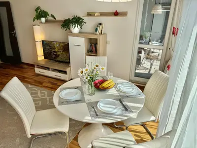 a dining room with a white table and chairs at Sunny & Comfort Apartment next to Tech Park for 4 Guests in Sofia