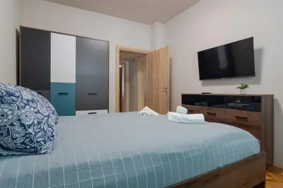 a bedroom with a bed and a flat screen tv at Spacious Sofia Condo - Philadelphia LOVE in Sofia