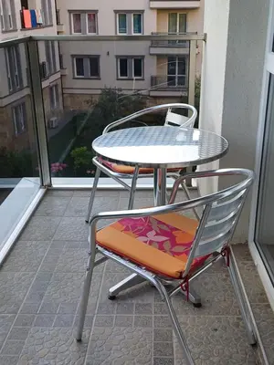 two chairs and a table on a balcony at Апартамент Престиж 1 in Hisarya