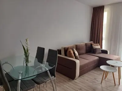 a living room with a couch and a glass table at Апартамент Престиж 1 in Hisarya
