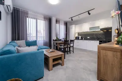 a living room with a blue couch and a kitchen at 1-Bedroom apartment with Free Private parking in Plovdiv