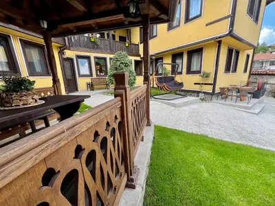 a backyard with a wooden fence and green grass at Китанова къща in Koprivshtitsa