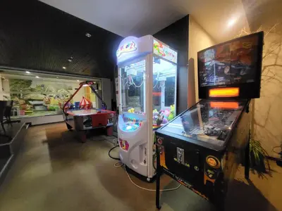 a video game arcade machine next to a table at Апартамент А101 хотел Снежанка in Pamporovo