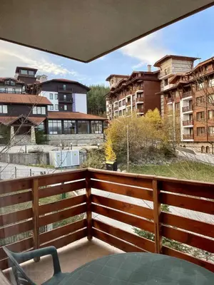 a balcony with a table and a view of buildings at Wonderful ski resort apartment in Bansko