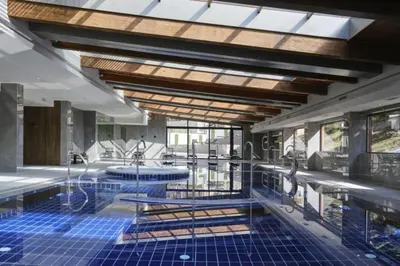 a swimming pool with blue tiles on the floor and windows at Wonderful ski resort apartment in Bansko