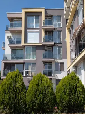 an apartment building with trees in front of it at Апартамент - Студио Престиж 2 in Hisarya