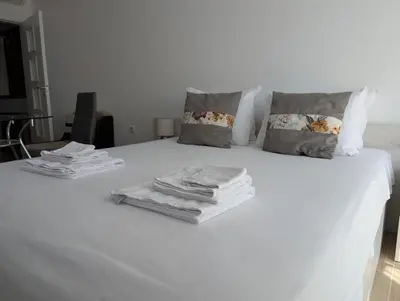 a white bed with towels and pillows on it at Апартамент - Студио Престиж 2 in Hisarya