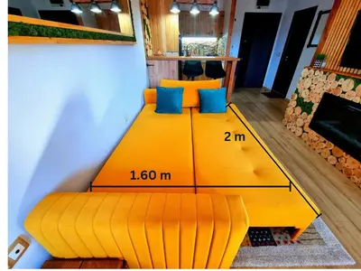a yellow bed in a room with a scale denominator at Wooden Paradise Apartment next to Gondola in Bansko
