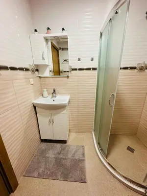 a small bathroom with a sink and a shower at Shtastliveca Guest Apartment in Velingrad