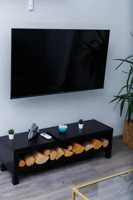 a black coffee table with a flat screen tv on a wall at Presidential neighbour retreat in Sofia