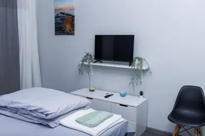 a bedroom with a desk with a tv and a chair at Presidential neighbour retreat in Sofia