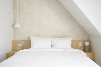 a white bed with two pillows in a bedroom at Hotel Hello Plovdiv - Free Parking and Pet Friendly in Plovdiv