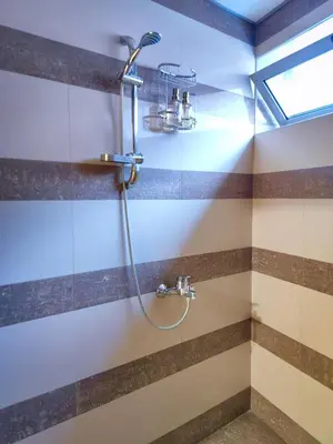 a shower in a bathroom with brown and white stripes at The View Apartment in Plovdiv