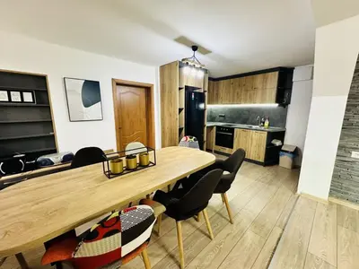 a kitchen and dining room with a wooden table and chairs at Вила Данели in Tsigov Chark