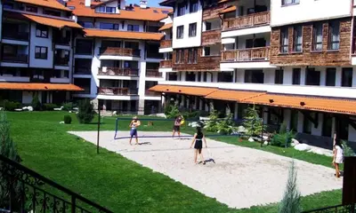 a group of people playing a game of volleyball in a park at Bansko Royal towers Ski Lift Area in Bansko