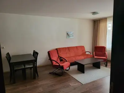 a living room with a red couch and two chairs at Bansko Royal towers Ski Lift Area in Bansko