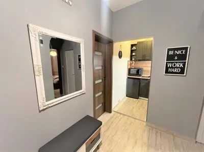 a small room with a mirror and a kitchen at Apartment in the Top center next to NDK in Sofia