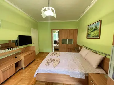 a bedroom with a bed and a flat screen tv at Mumbai Spacious 150 Sq M 2BDR near Vitosha BLVD and NDK in Sofia