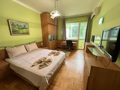 a bedroom with a bed and a desk and a television at Mumbai Spacious 150 Sq M 2BDR near Vitosha BLVD and NDK in Sofia