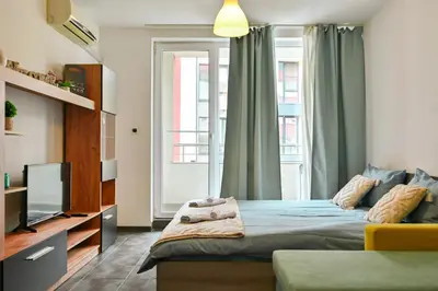 a small bedroom with a bed and a tv at Studio 19 in Sofia