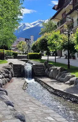 a water fountain in a park with a mountain in the background at apartment Serenity, Bansko in Bansko
