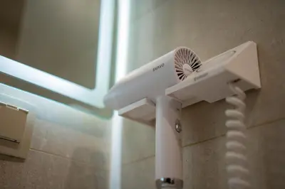 a white hair dryer is attached to a wall at Aurora Sofia in Sofia