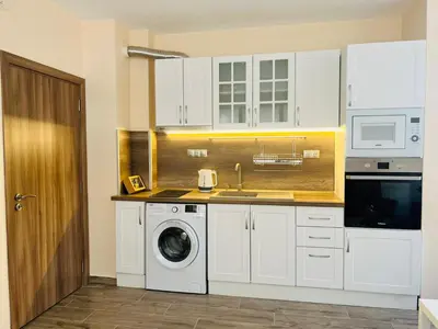 a kitchen with white cabinets and a washing machine at Cherry Apartment with 2 bedrooms in Sofia