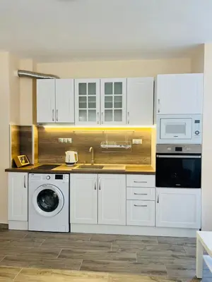 a kitchen with white cabinets and a sink and a dishwasher at Cherry Apartment with 2 bedrooms in Sofia