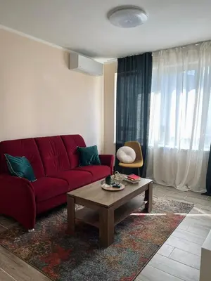 a living room with a red couch and a coffee table at Strаwberry Apartment in Sofia