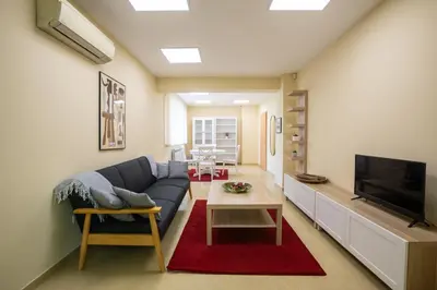 a living room with a couch and a tv at Bright 1BDR Apartment in Top Center in Sofia