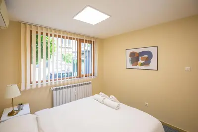 a bedroom with a white bed and a window at Bright 1BDR Apartment in Top Center in Sofia
