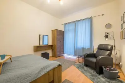 a bedroom with a bed and a couch and a chair at Stay and Play - Foosball and Comfort in Sofia