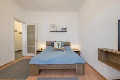 a bedroom with a bed with a blue blanket at Stay and Play - Foosball and Comfort in Sofia
