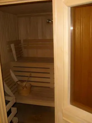 an open door of a sauna with a bucket at Predela 1 Bansko Apartment in Bansko