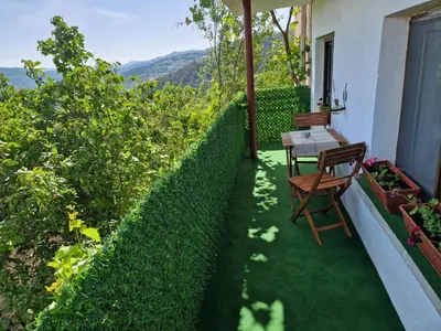 a patio with a table and chairs on a balcony at Вила Леска in Leska