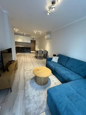a living room with a blue couch and a table at Lux City Apartment, free parking in Pazardzhik