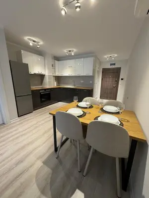 a dining room with a table and chairs and a kitchen at Lux City Apartment, free parking in Pazardzhik