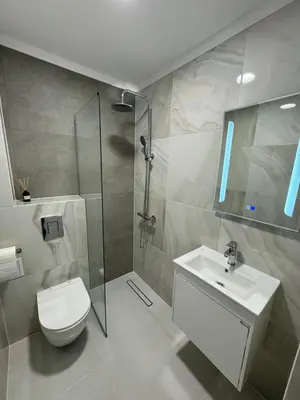 a bathroom with a toilet and a sink and a shower at Lux City Apartment, free parking in Pazardzhik