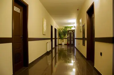 a hallway of a building with doors and a plant at Rubis Hotel in Rudozem