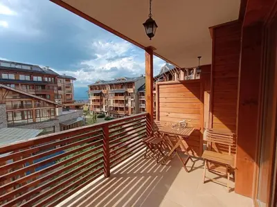 a balcony with a bench and a table on it at Apartment Saint Ivan Ski Resort in Bansko