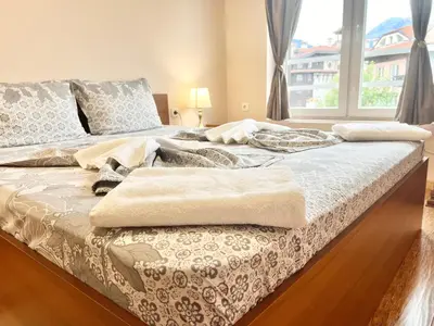 a large bed in a room with a window at Bojurland Apartment, Bansko in Bansko