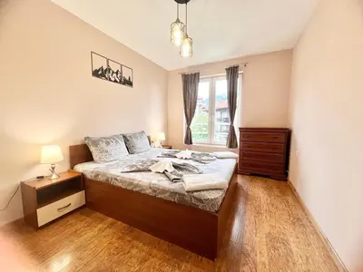 a bedroom with a bed and a window at Bojurland Apartment, Bansko in Bansko