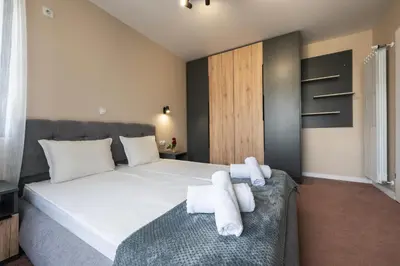 a bedroom with a large bed with towels on it at City Apartments 4 in Velingrad