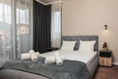 a bedroom with a large bed with white sheets and pillows at City Apartments 4 in Velingrad