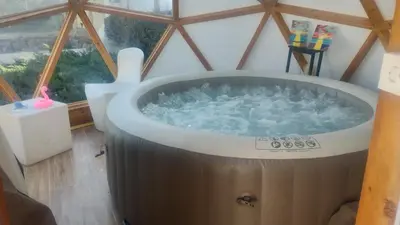 a large bath tub in a room with a window at Lea Hause with swimming pool,Jacuzzi in Vitosha montain and free parking in Sofia