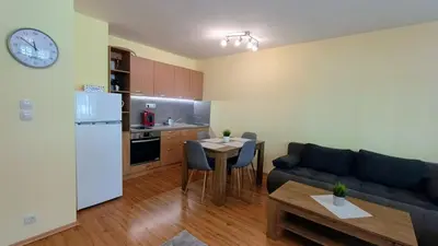 a kitchen and a living room with a couch and a table at Kandahar Private Apartments in Bansko