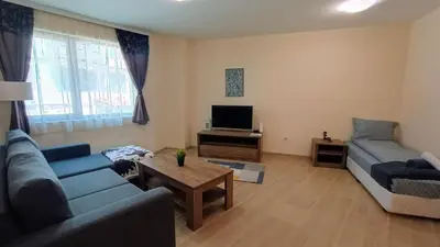 a living room with a blue couch and a tv at Kandahar Private Apartments in Bansko