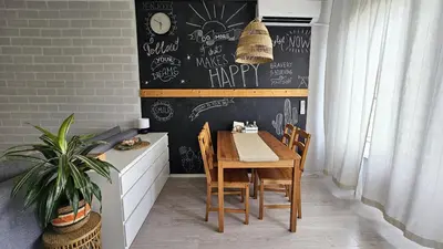 a dining room with a table and a chalkboard at Cozy Boho small apartment in Sofia