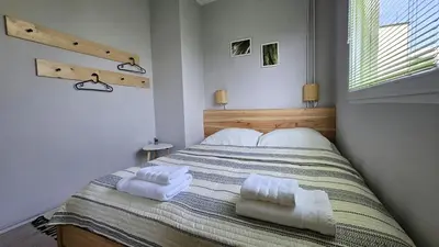 a bedroom with a bed with two towels on it at Cozy Boho small apartment in Sofia